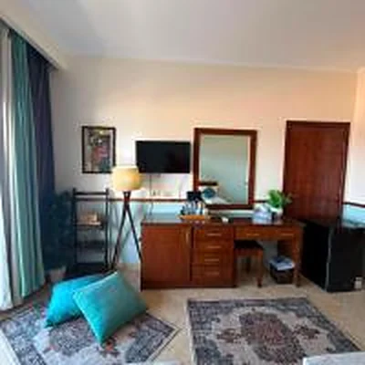The room interior, with a dresser and seating area.