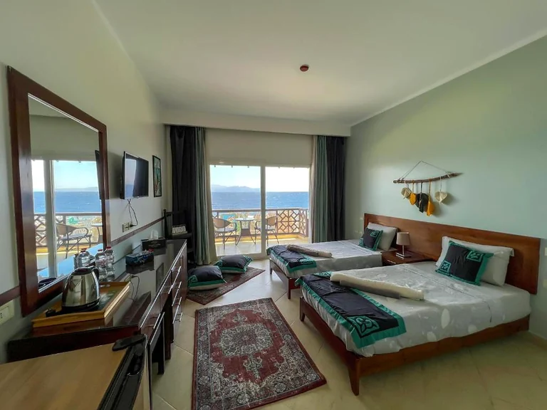 The twin room, with two beds and the sea visible through the balcony doors.
